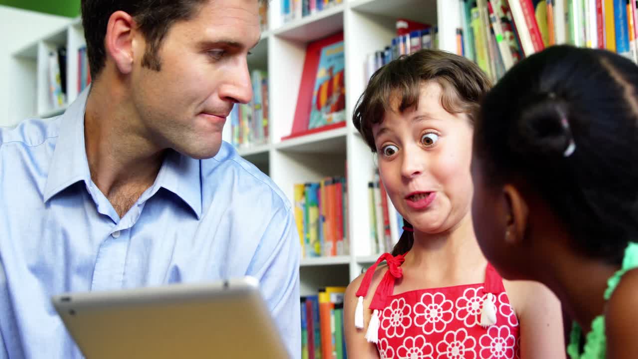 maestros y escolares usando tabletas digitales en la biblioteca de la escuela