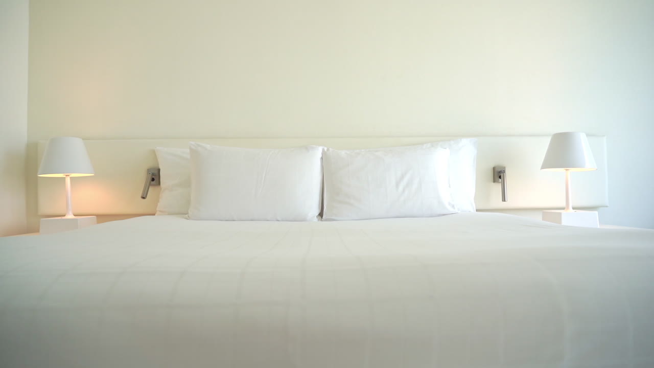 잘 정돈된 호텔 스위트룸 침대를 가로지르며