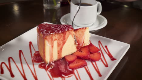 el tenedor se hunde en el pastel de queso de fresa, el café y el postre, la cena, el control deslizante en cámara lenta 4k