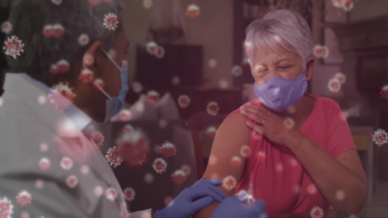 코로나19 세포가 여성 환자에게 코로나19 백신을 투여하는 남성 수석 의사에게 떠다니고 있습니다.