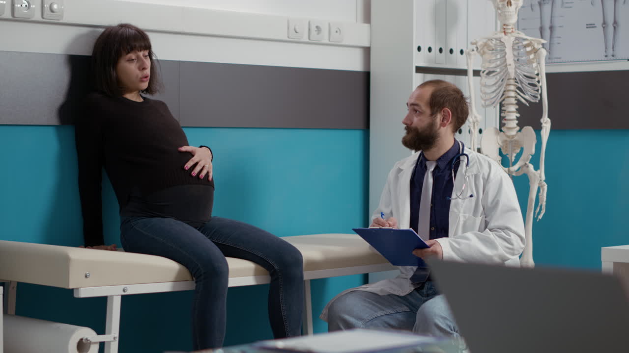 Giovane donna in attesa di un bambino a colloquio con un medico