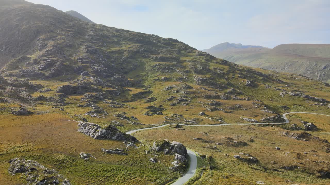 Una vista aerea di una strada di montagna e colline color arancio in autunno, in Irlanda.