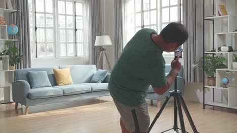 asian man blogger shoots video content for social networks by smartphone camera, magician with red ball