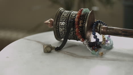 slider shot of a ritual tibetan prayer wheel resting on a white marble slab in 4k uhd