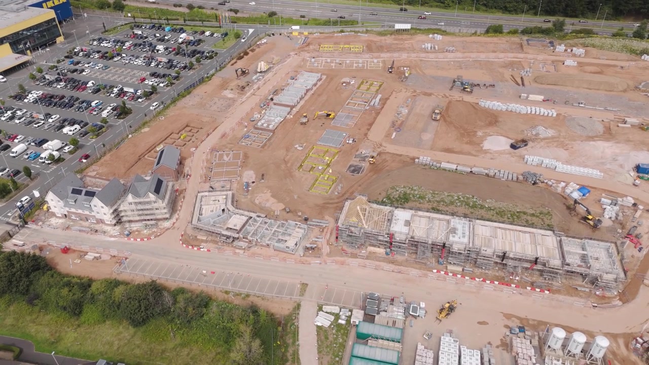 Drone-captured orbital view of a new residential development, highlighting the design and placement of houses within the newly built neighborhood in England