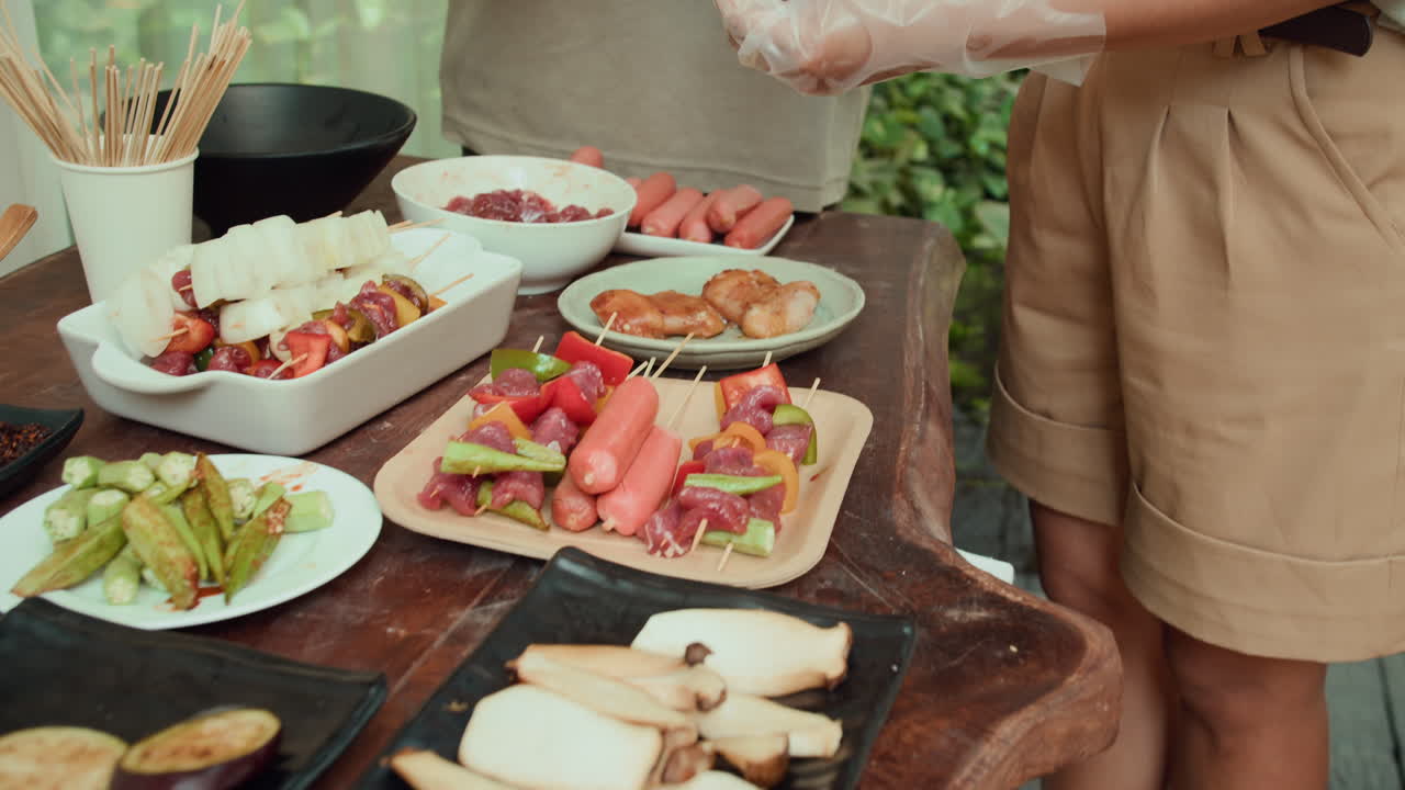 Unrecognizable People Cooking Skewers at Outdoor Kitchen