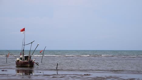 wooden boats on the beach which are moored, because the fishermen do not go to sea, the waves are swaying