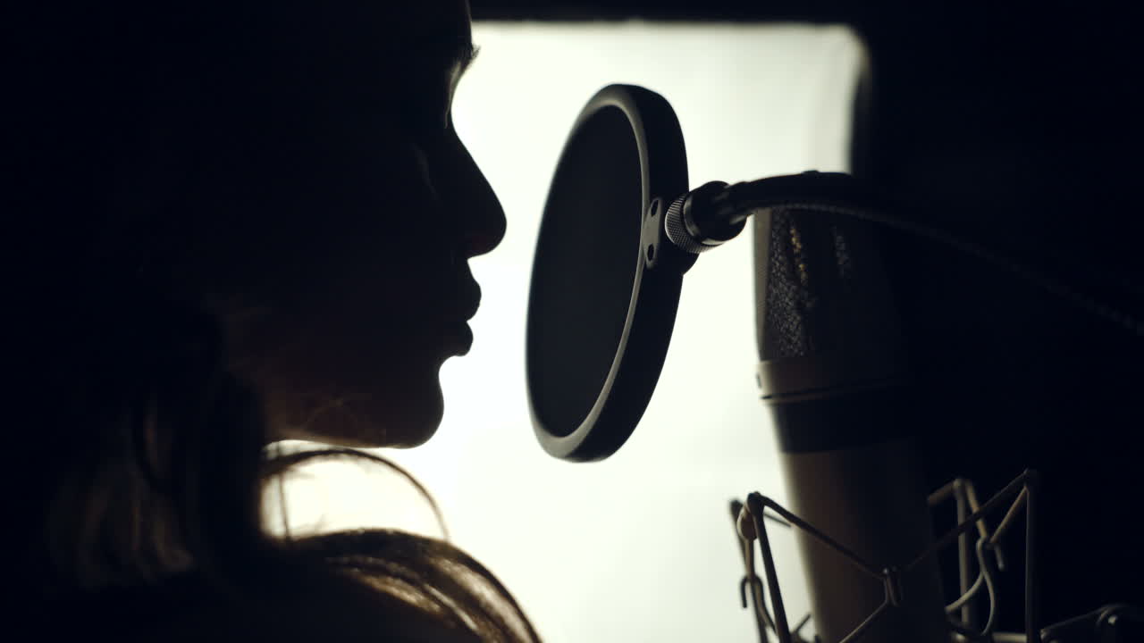 Woman singing in the recording studio. Profile of a woman with a beautiful face and lips. Black and White