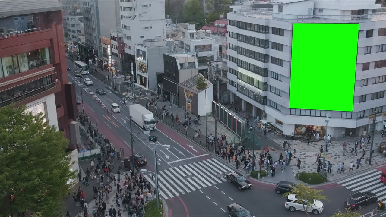 광고를 위해 녹색 스크린을 가진 큰 광고판, 현대적인 건물, 네온 조명과 함께 바쁜 교차로, 교통, 군중, 도쿄, 일본.
