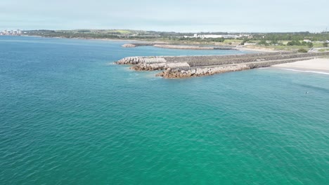 Serene coastal breakwaters meet turquoise sea at Praia de São Torpes, Alentejo