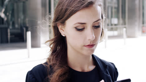 attractive business woman commuter using smartphone in city of london
