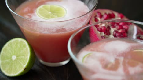 adding a lime slice into pomegranate cocktail creating a pomegranate cocktail concoction juicing and using fresh ingredients and pomegranate seeds