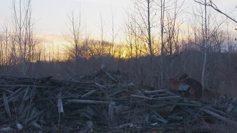 tilt up shot of a pile of discarded railroad ties to the sky at sunset