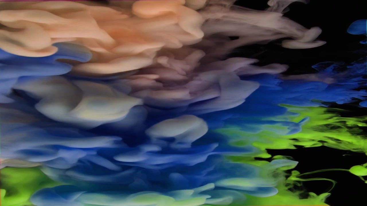 Nuvole d'inchiostro colorate vorticose nell'acqua su sfondo nero