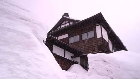 Nevó-En-Un-Edificio-De-Madera-Con-Altos-Muros-De-Nieve-Que-Lo-Rodeaban