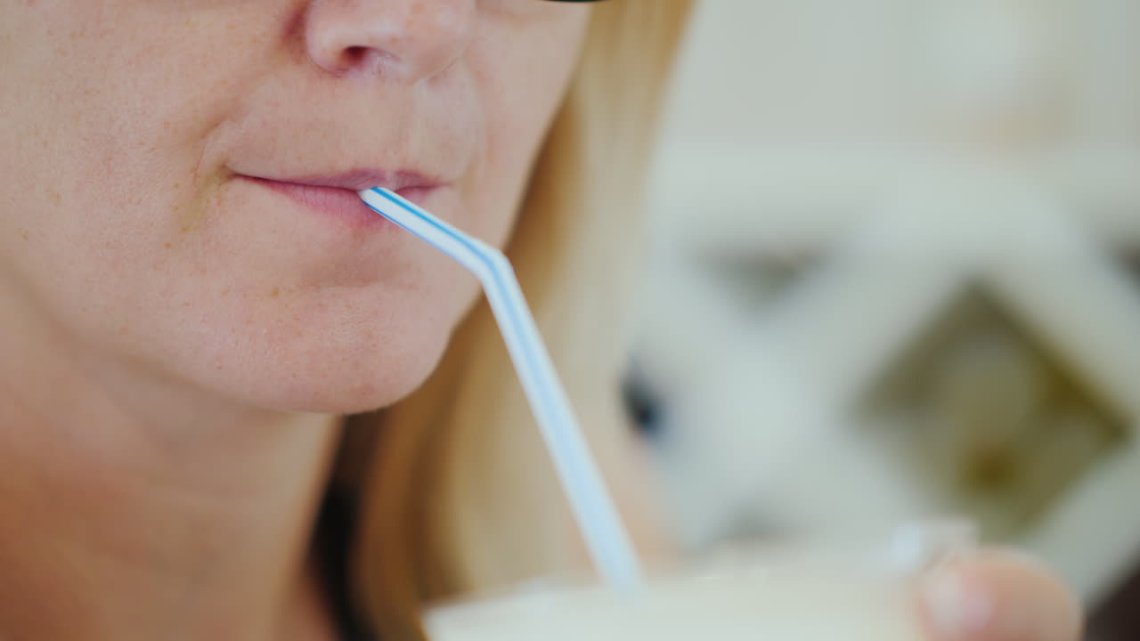 여자는 빨대에서 얼음과 와인에서 차가운 음료를 마신다