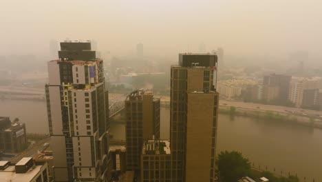 Aerial-view-rising-from-a-rooftop-terrace,-overlooking-the-Harlem-cityscape-covered-in-wildfire-smoke