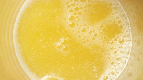 top view of tablets dissolving in yellow drink, water fizzing background