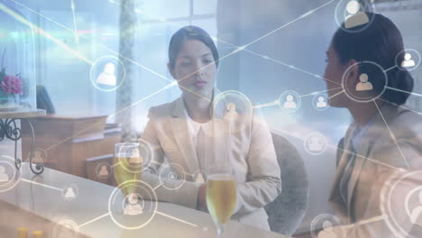 Discussing digital network connections, businesswomen analyzing data processing in office