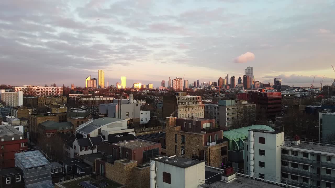 Rising up above City of London during amazing sunset. Aerial panoramic view.
