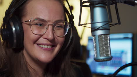 positive presenter speaks into the microphone in the studio, during the live broadcast