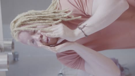 albino man with dreadlocks looking at his reflection