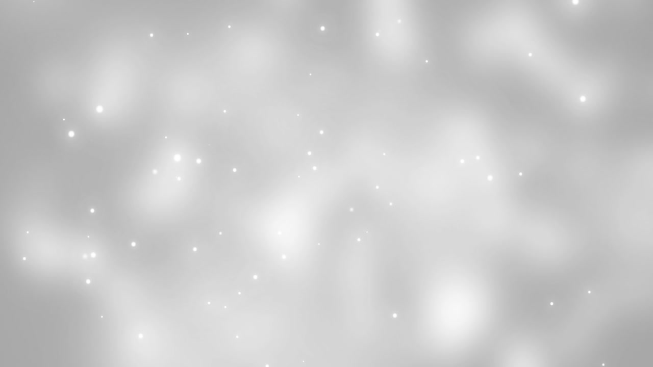 Glowing white christmas light particles falling on grey bokeh background