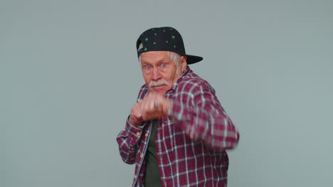 senior old man making fight threat at camera, shaking fist punch, boxing with expression punishment