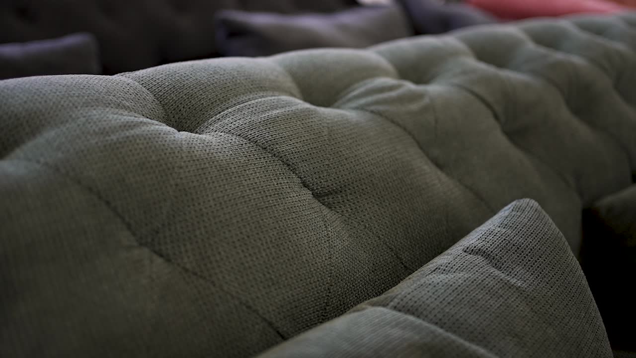 This video showcases a close view of a plush sofa, highlighting its unique texture and intricate stitching. The cozy living room invites relaxation and comfort