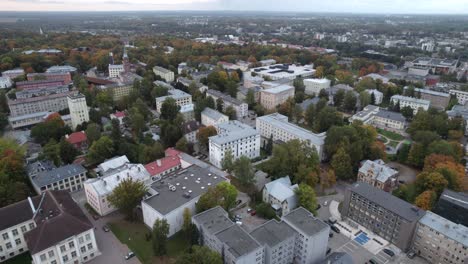 Drone-flying-over-Tartu-downtown,-in-beginning-of-autumn-some-trees-are-already-chaining-color-of-leaves