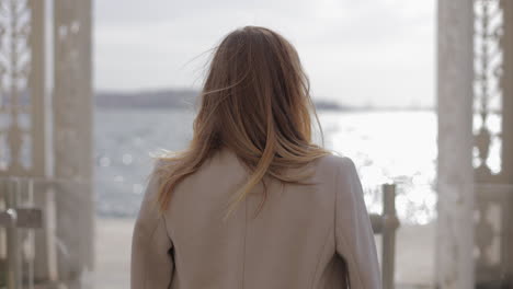 woman looking out at the sea from an architectural structure.