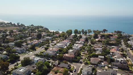 sobrevuelo aéreo de pacific palisade, suburbio de los ángeles con vista al océano y playa de arena