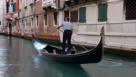 a gondolier navigating a canal in venice, italy