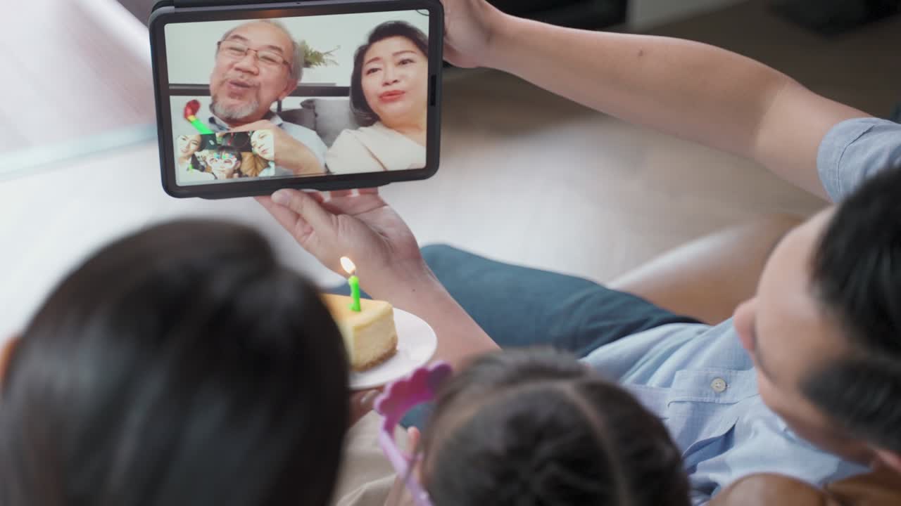 아시아의 노인 할아버지와 할머니는 사회적 거리를 지키는 동안 가정에서 비디오 통화를 통해 가상 생일을 축하하는 동안 사랑받고 행복하다고 느니다.