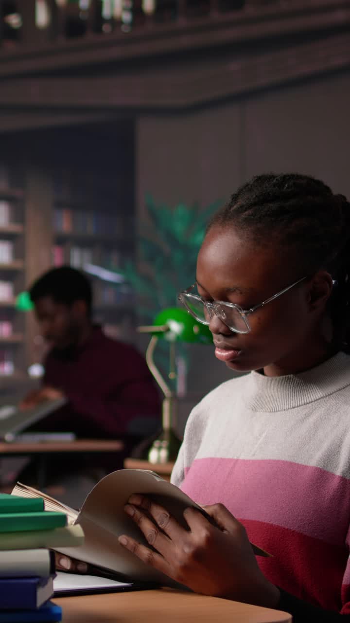 Vertical video black girl reading books and handwritten class notes right before the exam