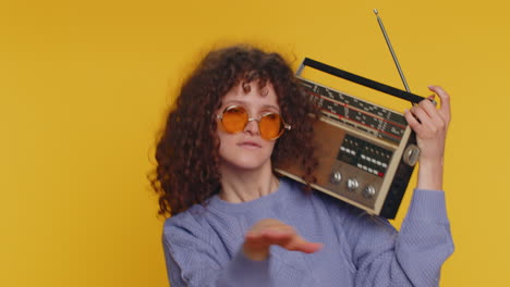 woman using retro tape record player to listen music, disco dancing of favorite track, having fun