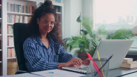 young successful indian woman finished printing and reclining back in chair