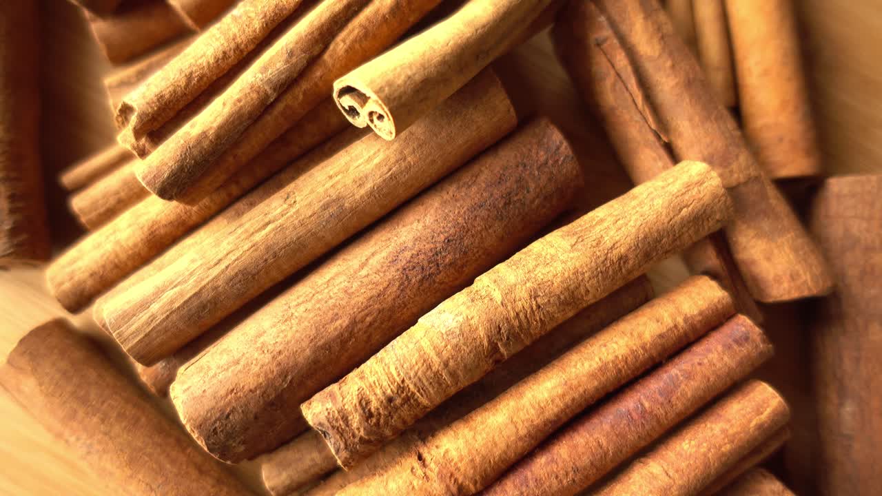 Bastoncini di cannella che ruotano come sfondo. Primo piano di cannella e spezie.