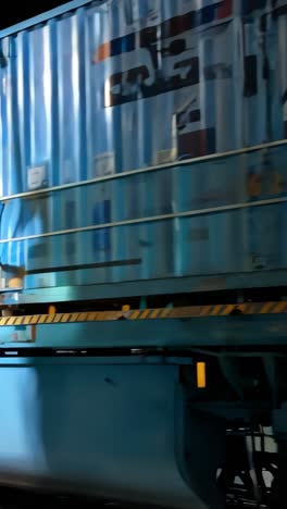 close-up of a blue freight train with shipping containers at night