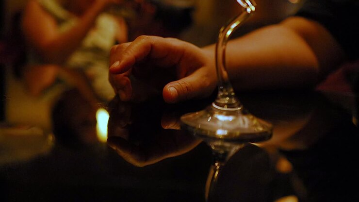 Hand tapping near a wine glass in Bangkok
