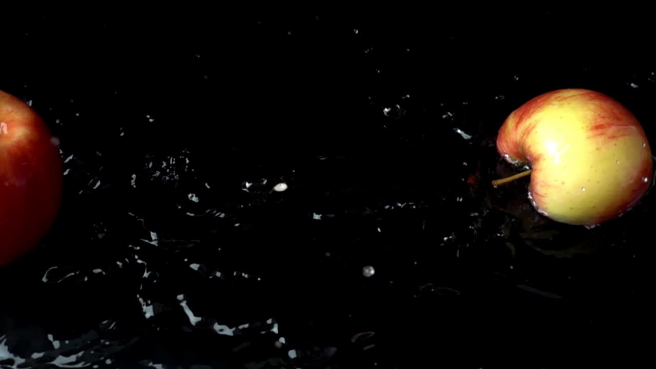 Apple falls in water. Slow motion