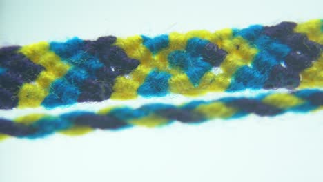 toma macro de una pulsera textil de tela azul y amarilla, 4k