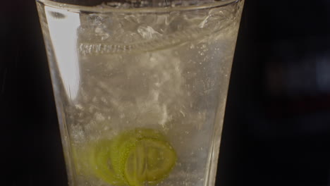 pouring a refreshing drink with lime and ice