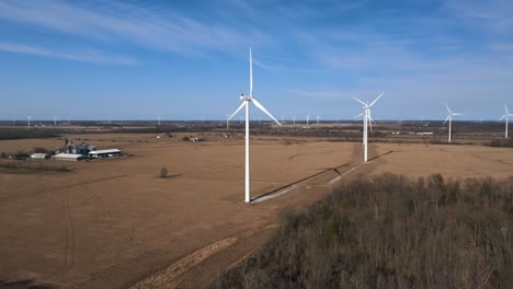 Aerial-shot-of-wind-turbines-in-a-rural-landscape-with-a-clear-sky