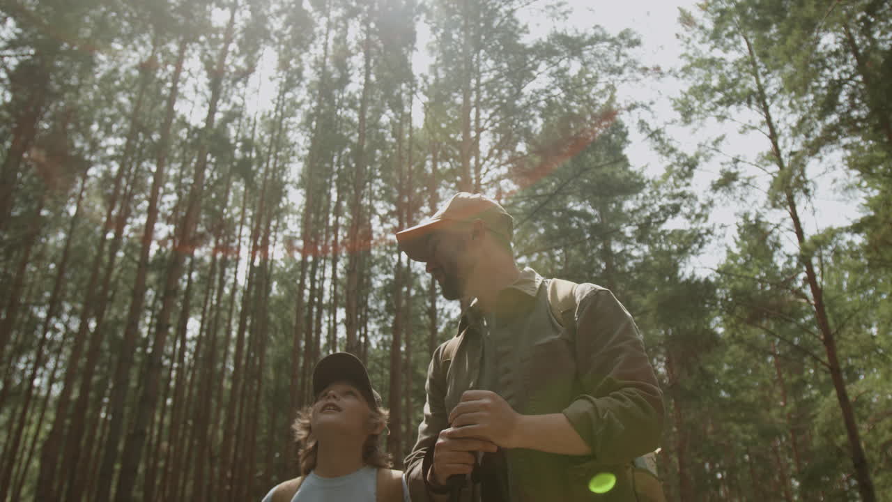 아버지 와 아들 이 숲 에서 하이킹 하고 있다