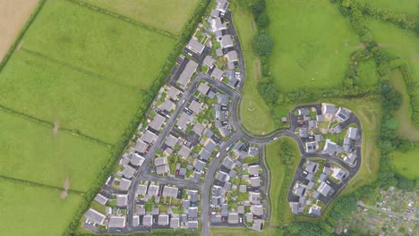 Strategic-housing-development-on-the-edge-of-a-settlement-in-the-UK,-captured-from-a-top-down-aerial-perspective