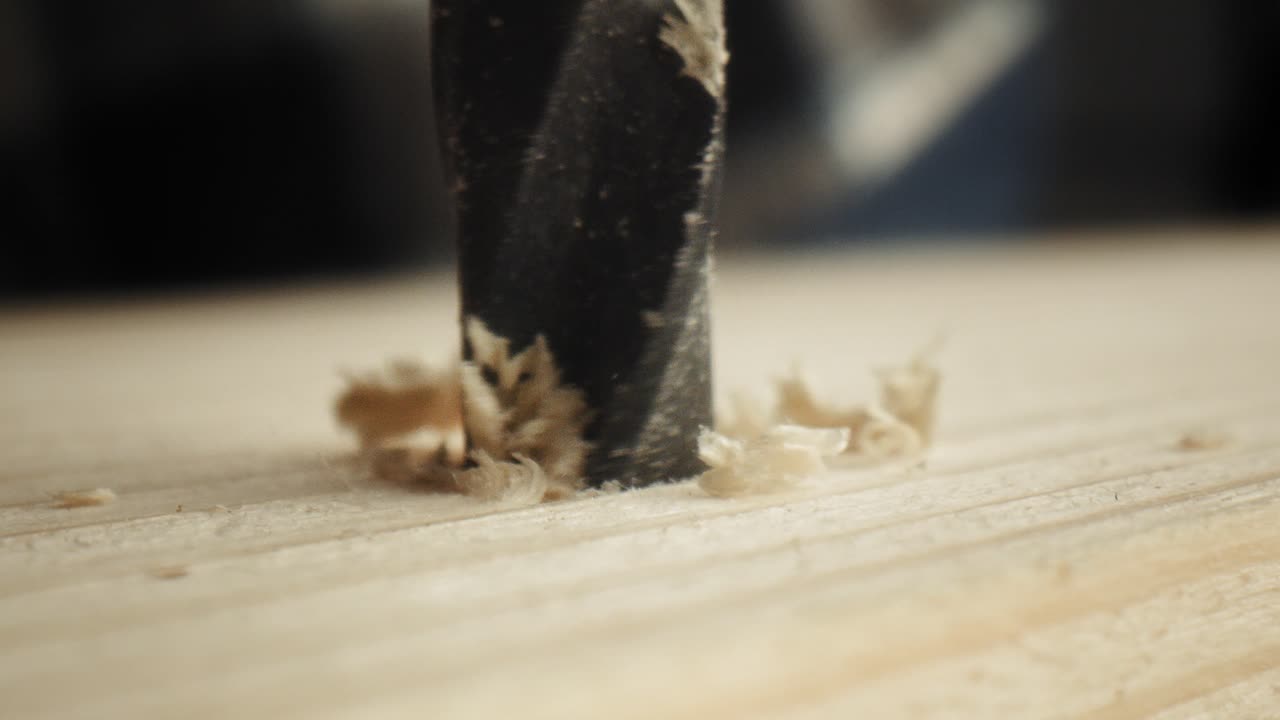 Close up static video of drilling on wood plate