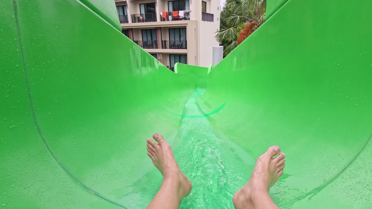 deslizándose por un vibrante tobogán de agua verde