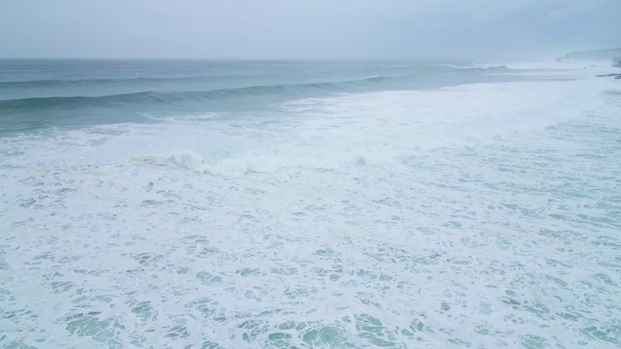 Gentle ocean waves crashing along the shore in Aljezur, Portugal, calm and peaceful