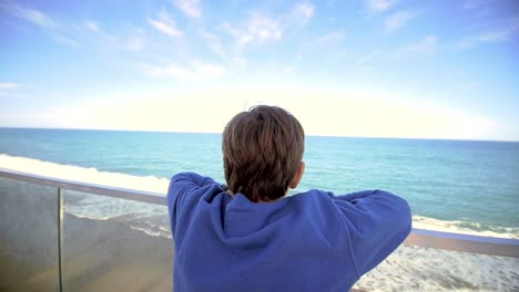 young boy looking out over ocean 03